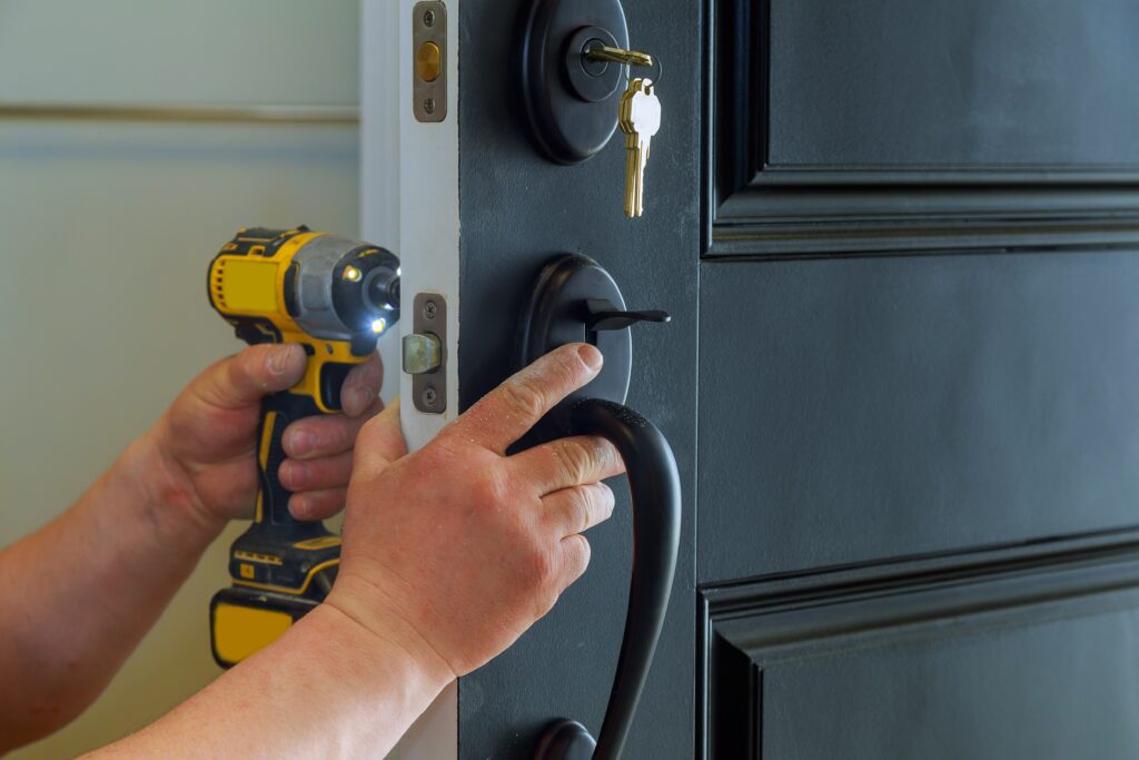 Closeup of a professional locksmith installing a new lock on a house exterior door with the inside